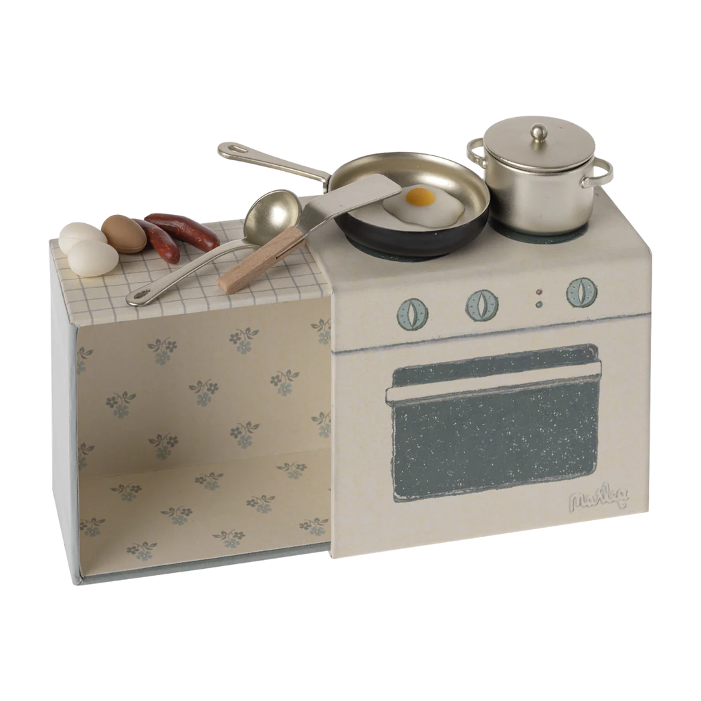Mini cucina con attrezzi e uova e salsicce