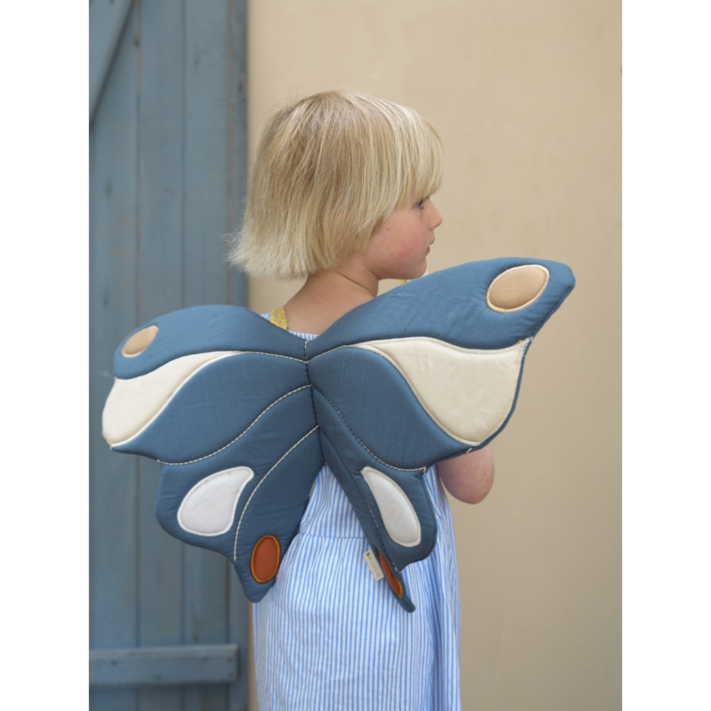 Bambina che indossa ali farfalla in cotone di colore blu