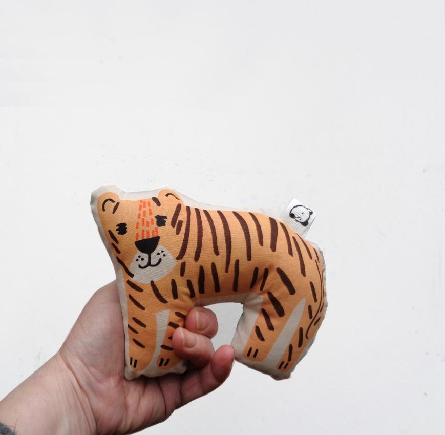 Sonaglio di stoffa a forma di tigre serigrafato tenuto da una mano