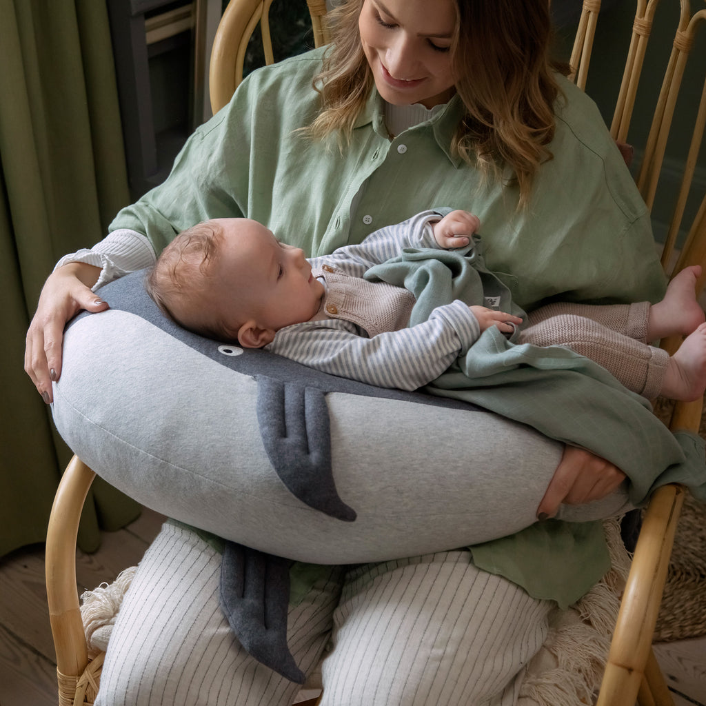 Mamma che utilizza il cuscino di allattamento a forma di balena