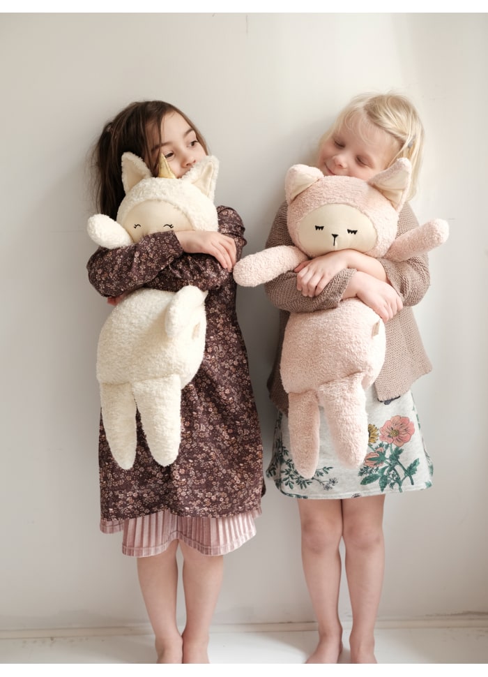 Due bambine abbracciate ciascuna  a conigliette peluche formato grande