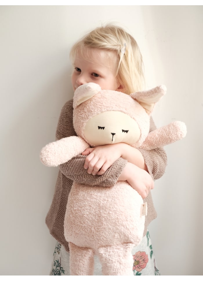 Bambina che abbraccia il peluche coniglietta grande