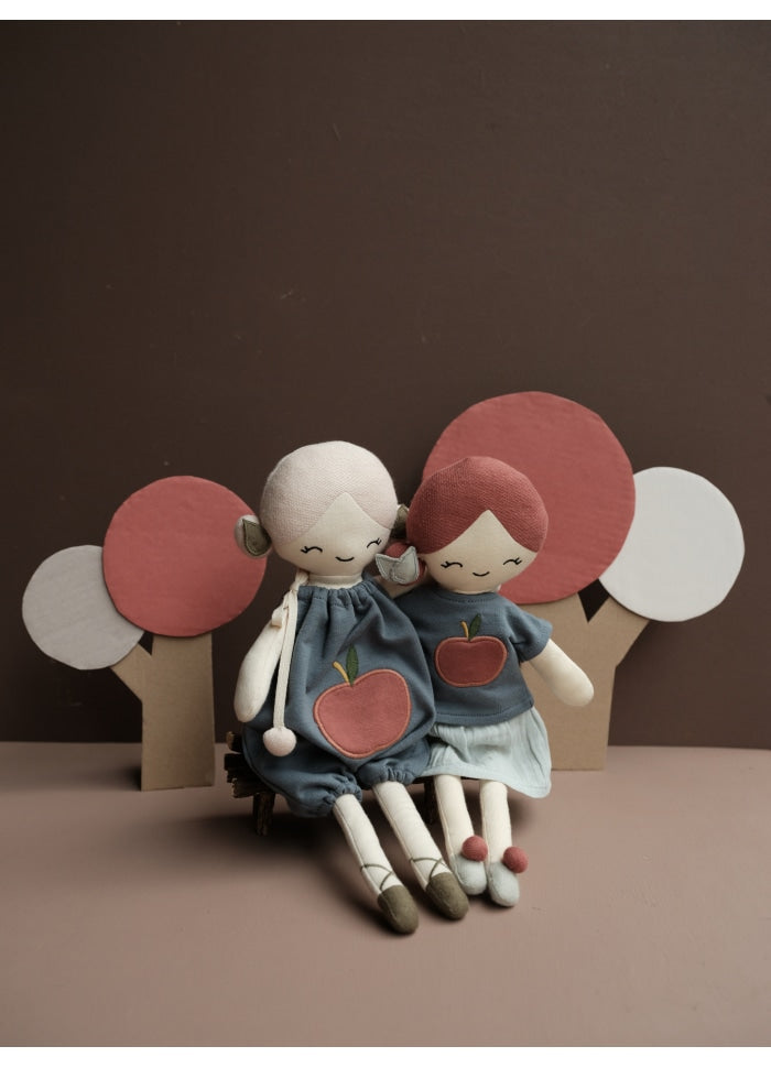 Coppia di bambole in stoffa sedute con vestitini caratterizzati dalla stampa di una ciliegia rossa