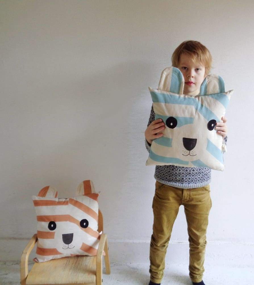 Cuscino in cotone a forma di orsetto in mano ad un bambino 