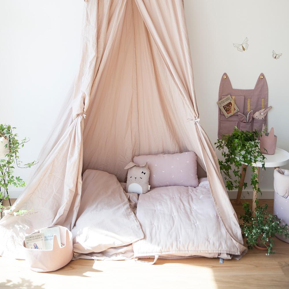 Cuscino in cotone,  color malva, a forma di coniglietta su un letto