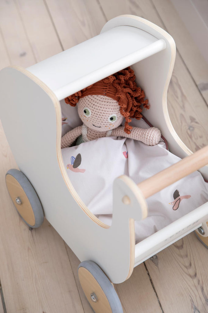 Carrozzina per bambole in legno bianco con dentro una bambola ad uncinetto
