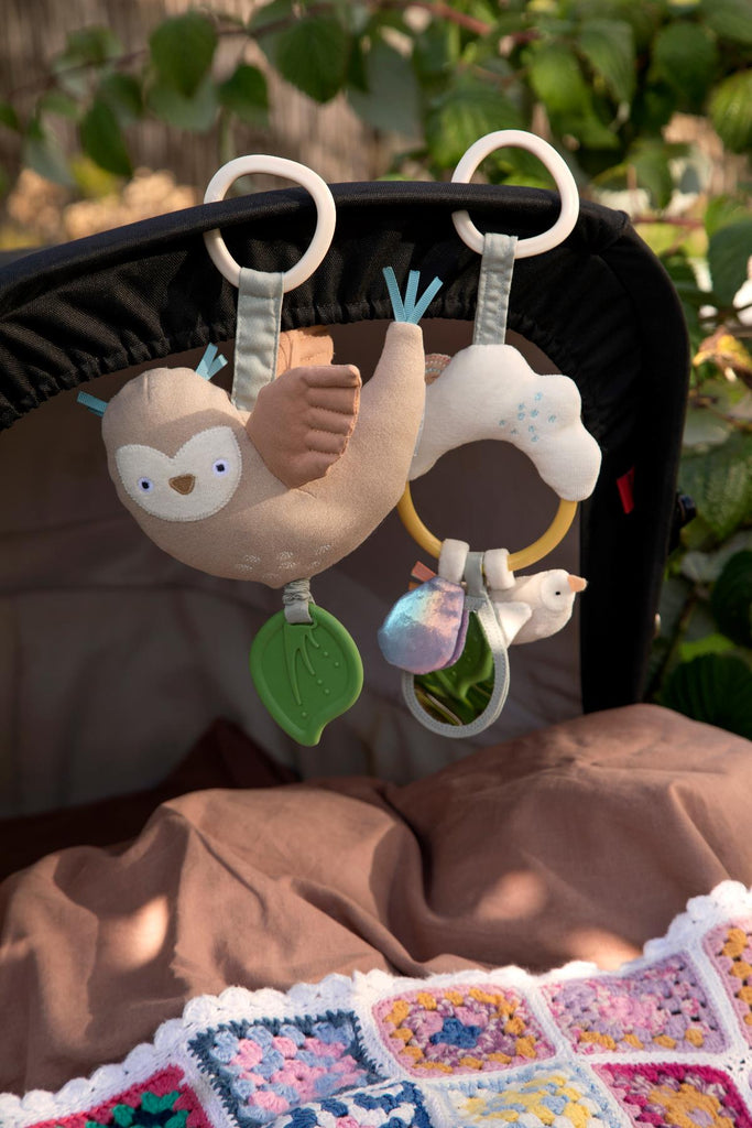Gioco activity per neonati fatto ad anello con nuvola e uccellino appeso alla copertura di una carrozzina