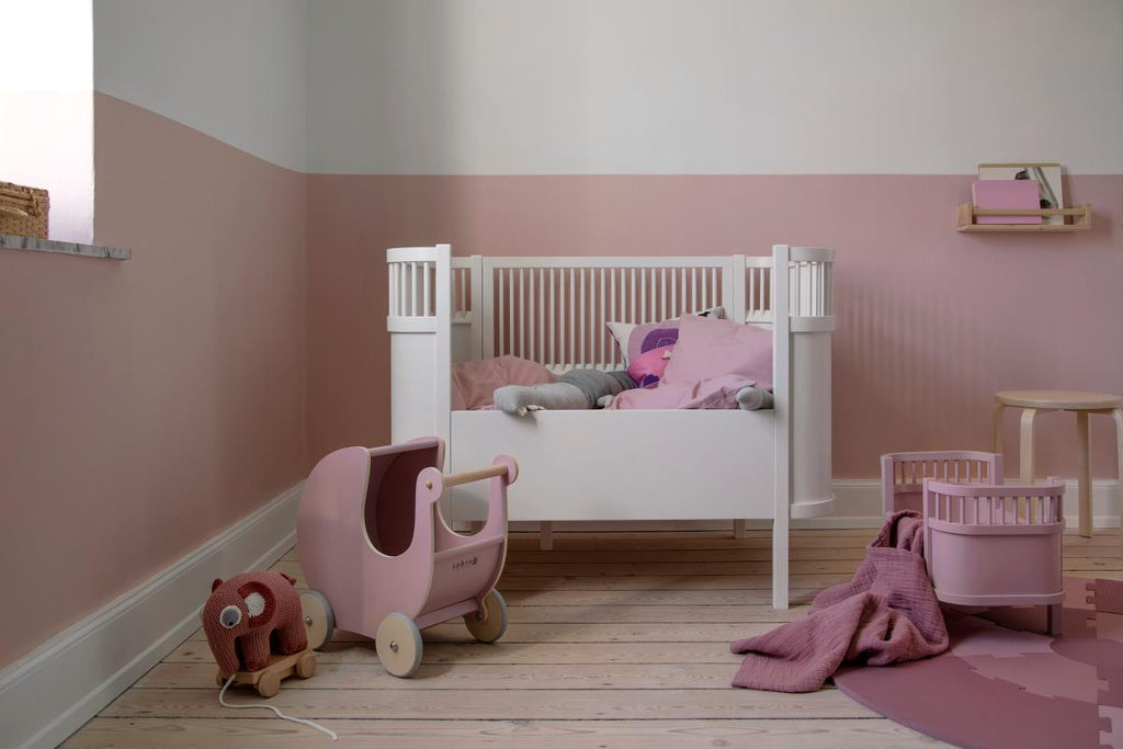 Copertina, color rosa, in mussola di cotone a trama fitta  in una cameretta  per bambina