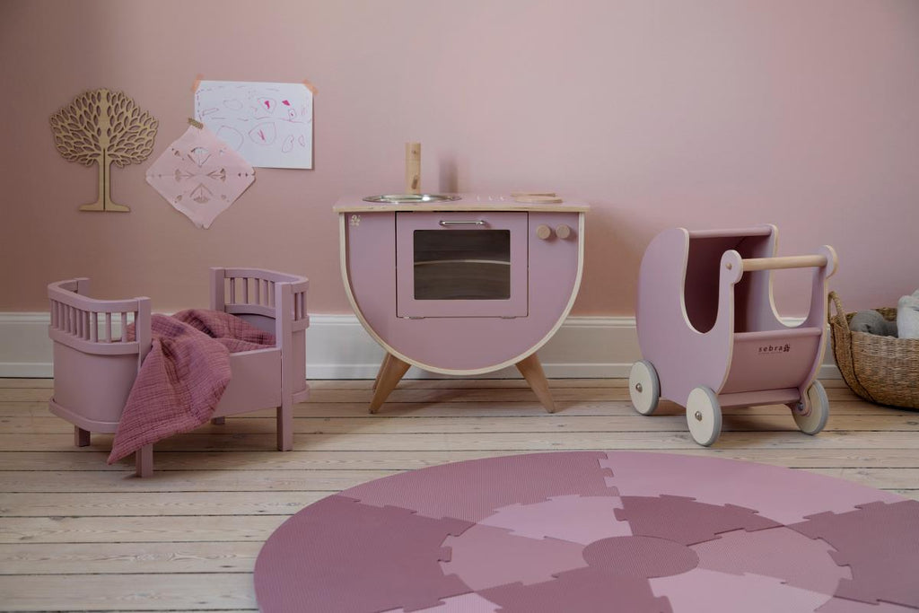 Copertina, color rosa, in mussola di cotone a trama fitta in una cameretta per bambina