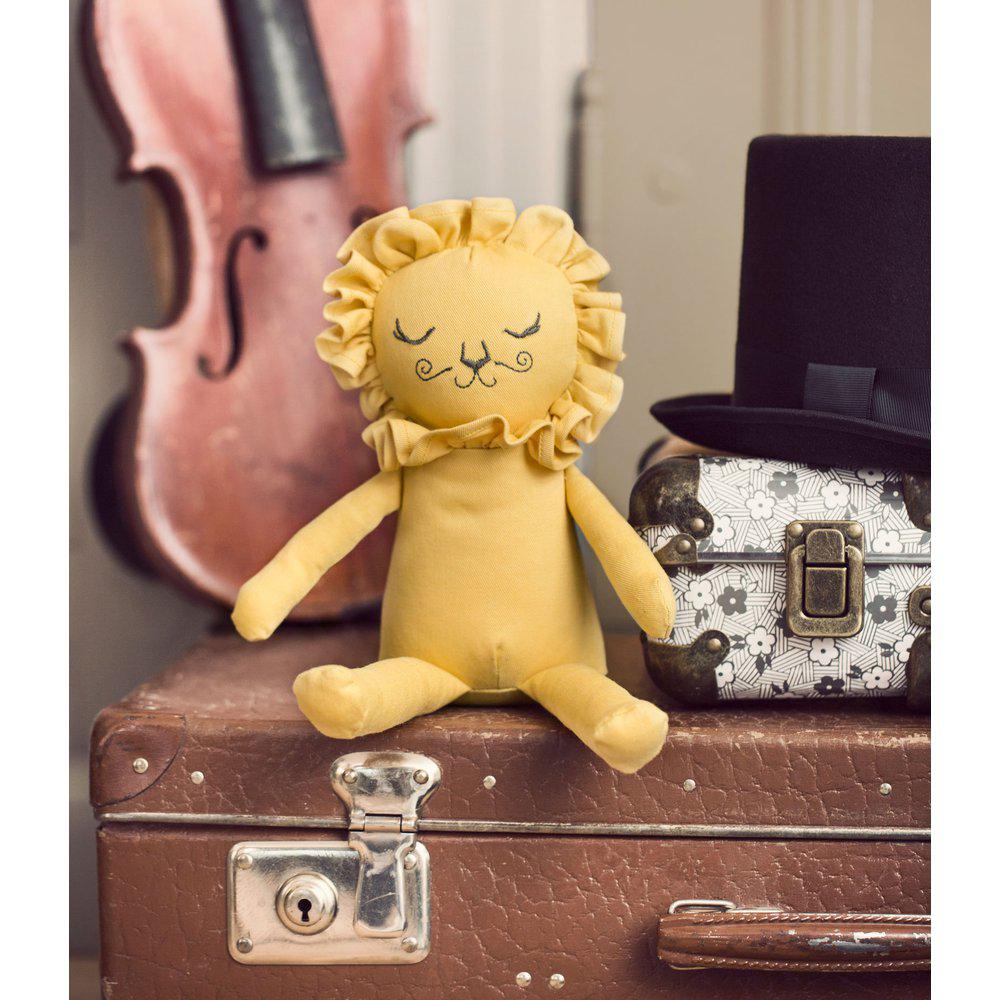 Bambola di stoffa color miele con viso da leoncino con criniera. SEduto su una valigetta
