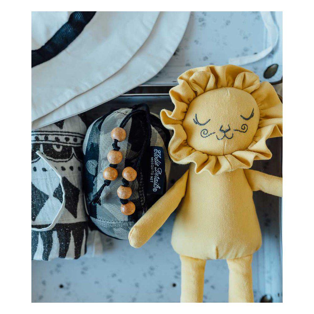 Bambola di stoffa color miele con viso da leoncino con criniera. In piedi con altri oggetti