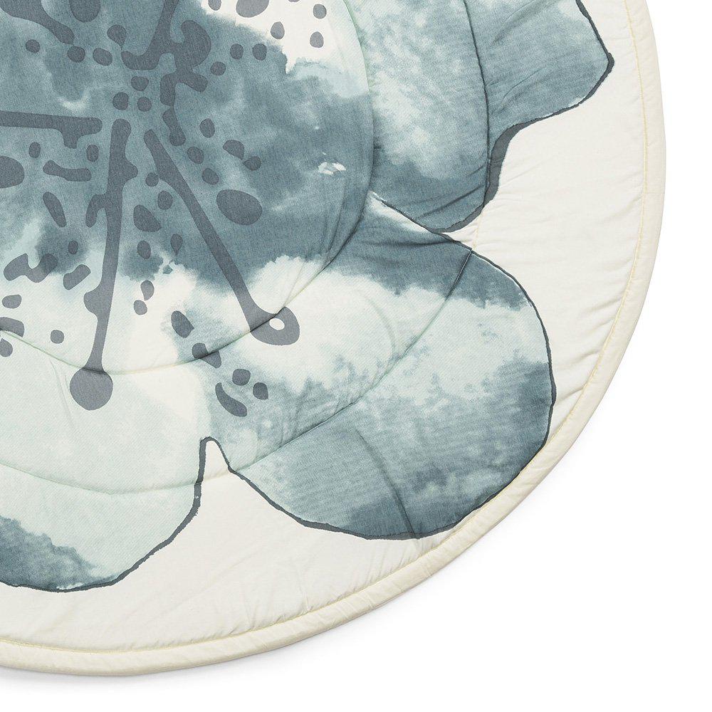 Tappeto gioco rotondo con disegno acquarello di un grande fiore color petrolio. Dettaglio del fiore