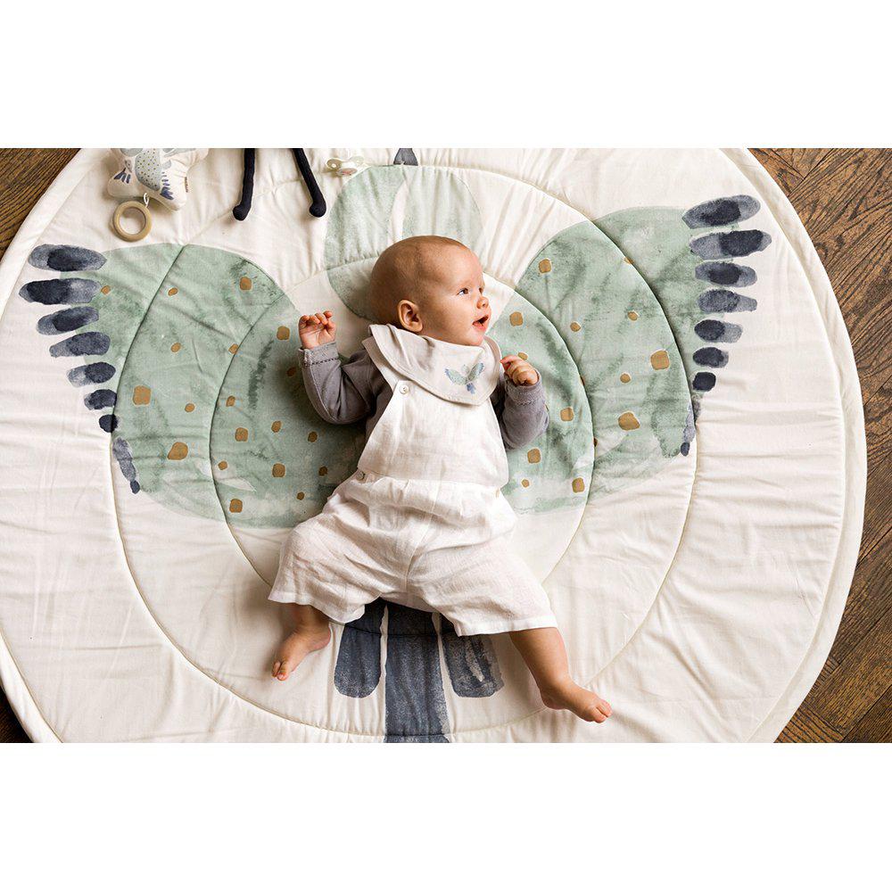 Tappeto gioco rotondo con il disegn ocolorato di una aquila a ali spiegate con sopra un neonato