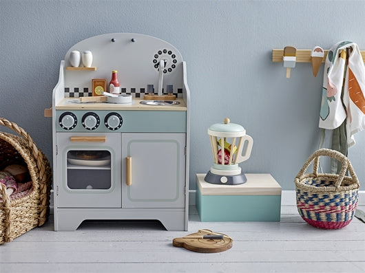 Cucina giocattolo in legno grigio; con fuochi,lavello e forno. Ambientata in una cameretta