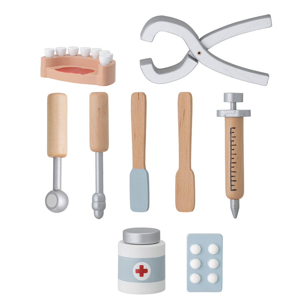 Set di strumenti del dentista in legno: una pinza, una siringa e anche una dentiera, un blister di pastiglie e un tubetto di medicine.