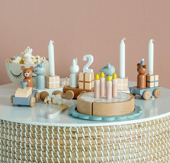 Trenino multicolore in legno porta candele con figurine di animali insieme a una torta di compleanno in legno