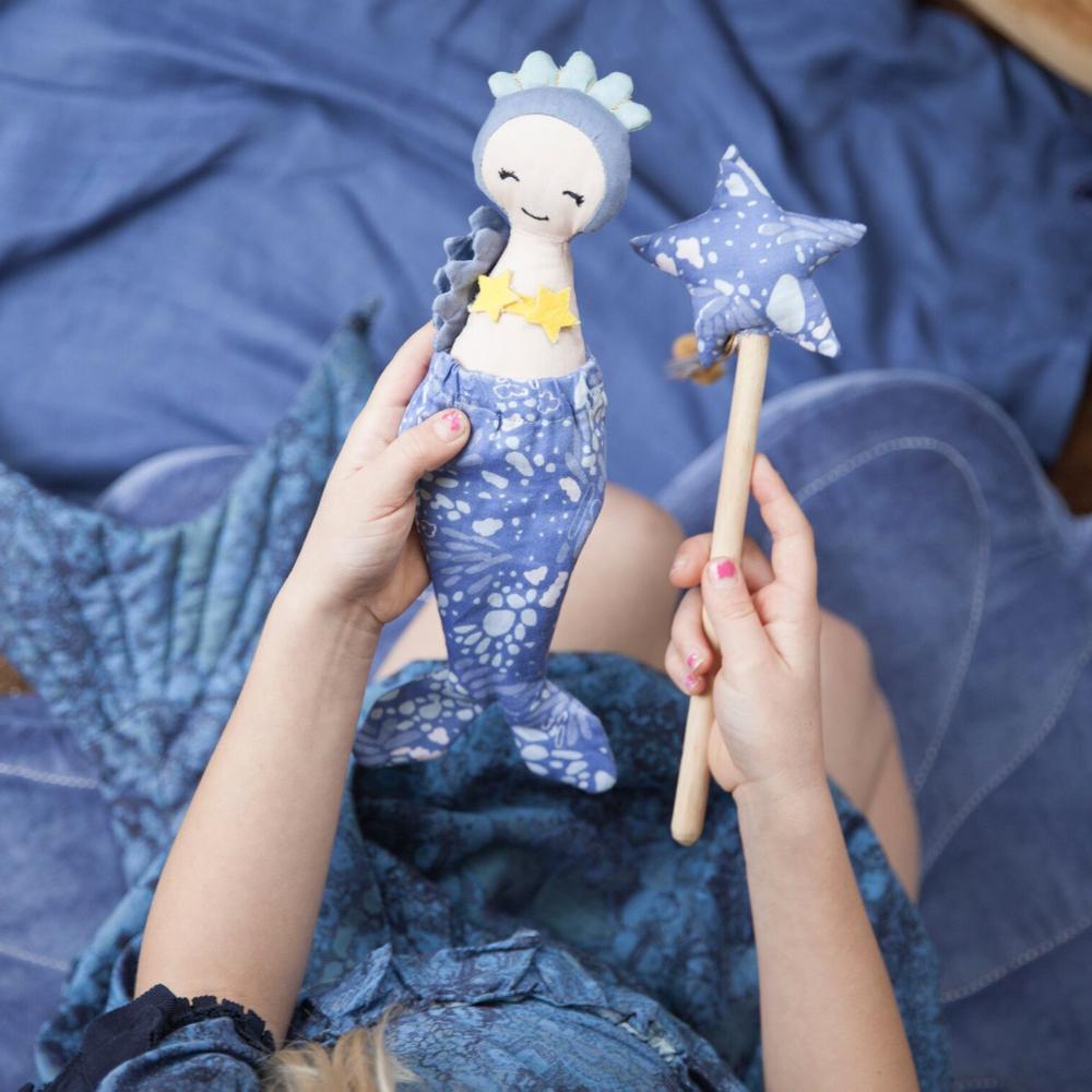 Bambola di stoffa a forma di sirenetta nella mani di una bambina