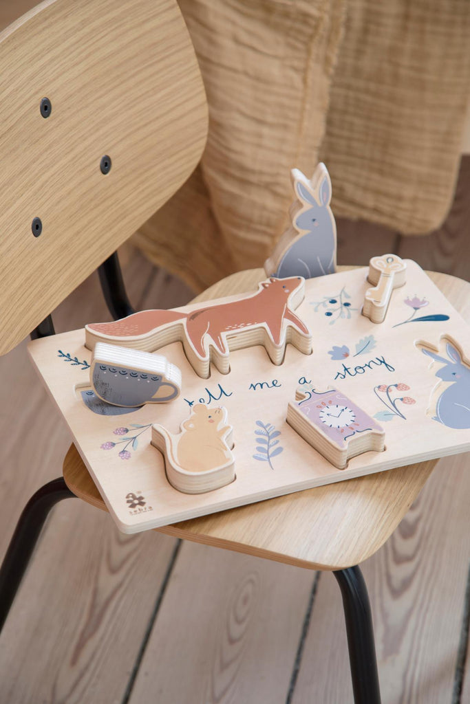 Puzzle in legno con tessere a figura di animali sopra una sedie