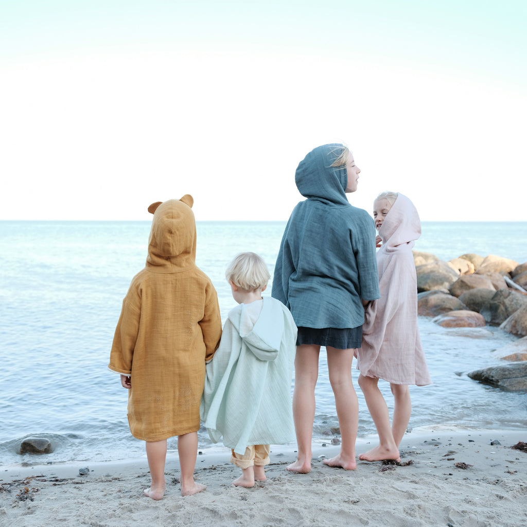 Gruppo bambini in accappatoio in riva al mare